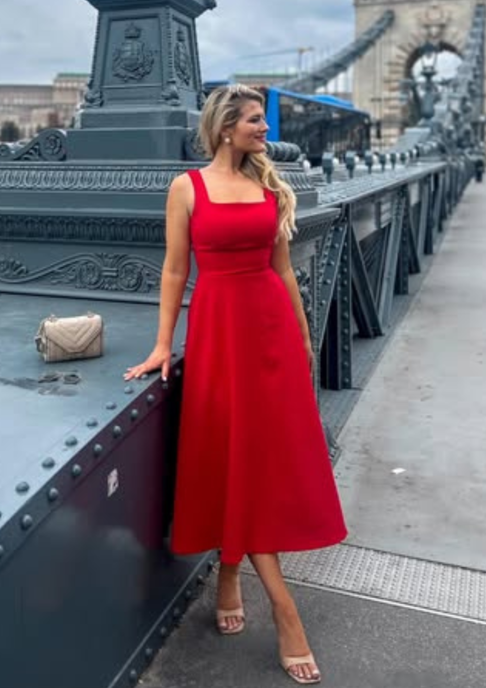 woman wearing a diva catwalk Tamsin Square Neckline Swing Dress sleeveless style with a midaxi  length and side pockets in Scarlet Red colour in Budapest