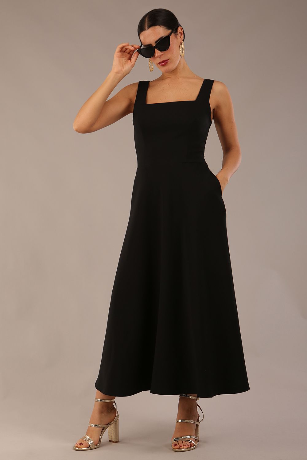 model wearing a diva catwalk Tamsin Square Neckline Swing Dress sleeveless style with a midaxi  length and side pockets in Black colour