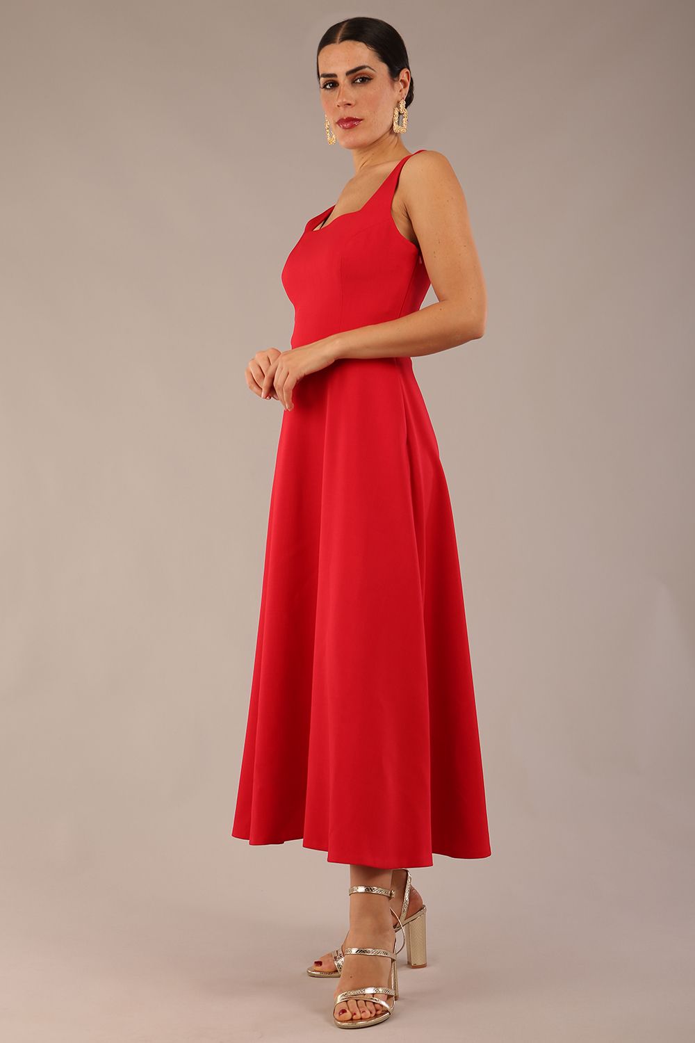 model wearing a diva catwalk Tamsin Square Neckline Swing Dress sleeveless style with a midaxi  length and side pockets in Scarlet Red colour