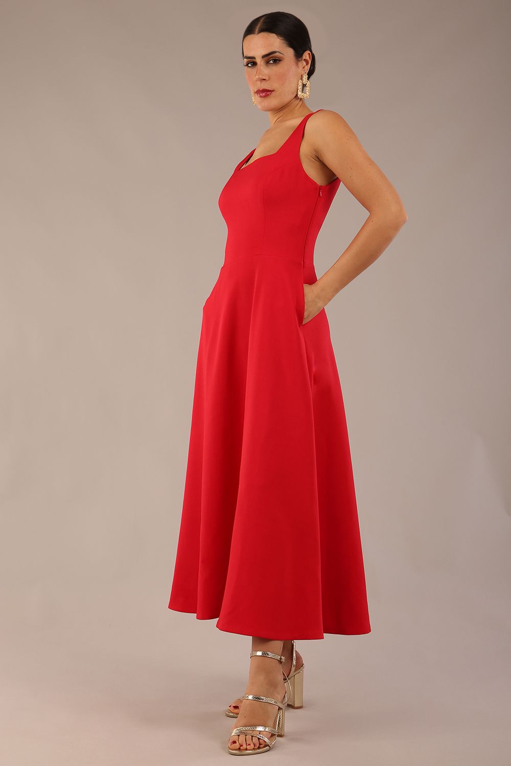 model wearing a diva catwalk Tamsin Square Neckline Swing Dress sleeveless style with a midaxi  length and side pockets in Scarlet Red colour