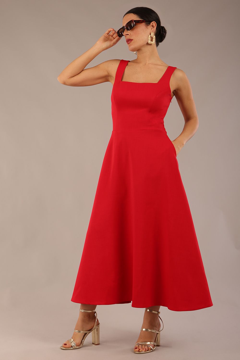 model wearing a diva catwalk Tamsin Square Neckline Swing Dress sleeveless style with a midaxi  length and side pockets in Scarlet Red colour