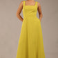 brunette model is wearing a diva catwalk Tamsin Square Neckline Swing Dress sleeveless style with a midaxi  length and side pockets in Citrus green colour front