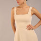 brunette model is wearing a diva catwalk Tamsin Square Neckline Swing Dress sleeveless style with a midaxi  length and side pockets in sandshell beige colour front close up