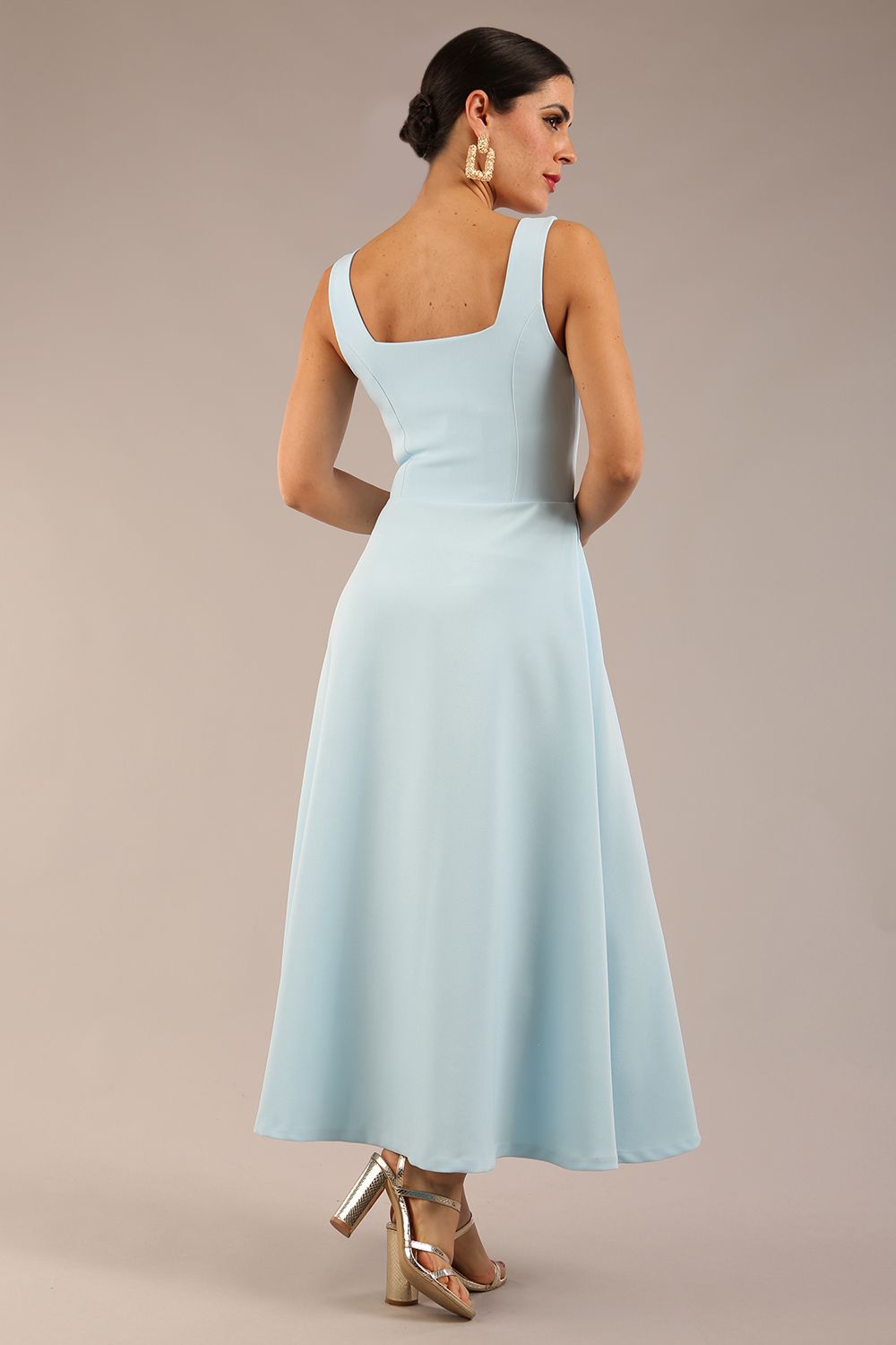 brunette model is wearing a diva catwalk Tamsin Square Neckline Swing Dress sleeveless style with a midaxi  length and side pockets in Sky blue colour back