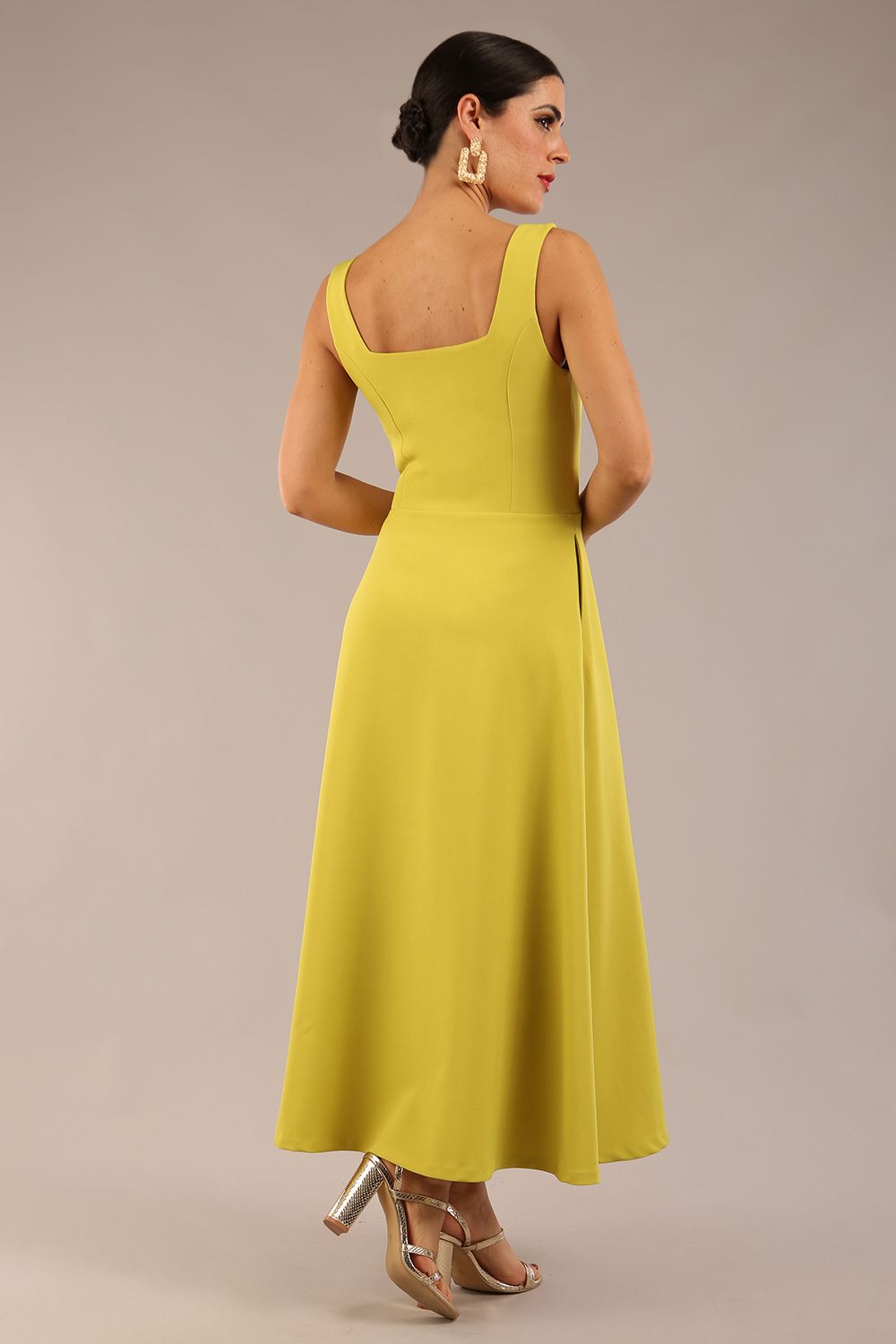 brunette model is wearing a diva catwalk Tamsin Square Neckline Swing Dress sleeveless style with a midaxi  length and side pockets in Citrus green colour back