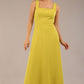 brunette model is wearing a diva catwalk Tamsin Square Neckline Swing Dress sleeveless style with a midaxi  length and side pockets in Citrus green colour front
