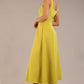 brunette model is wearing a diva catwalk Tamsin Square Neckline Swing Dress sleeveless style with a midaxi  length and side pockets in Citrus green colour back side