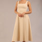 brunette model is wearing a diva catwalk Tamsin Square Neckline Swing Dress sleeveless style with a midaxi  length and side pockets in sandshell beige colour front