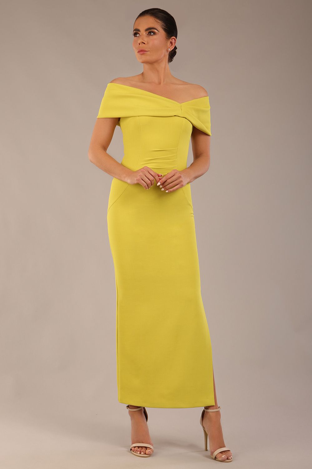 brunette model is wearing a diva catwalk Mariposa Longer Length Dress off the shoulder bardot neckline and midaxi length in citrus green colour front image