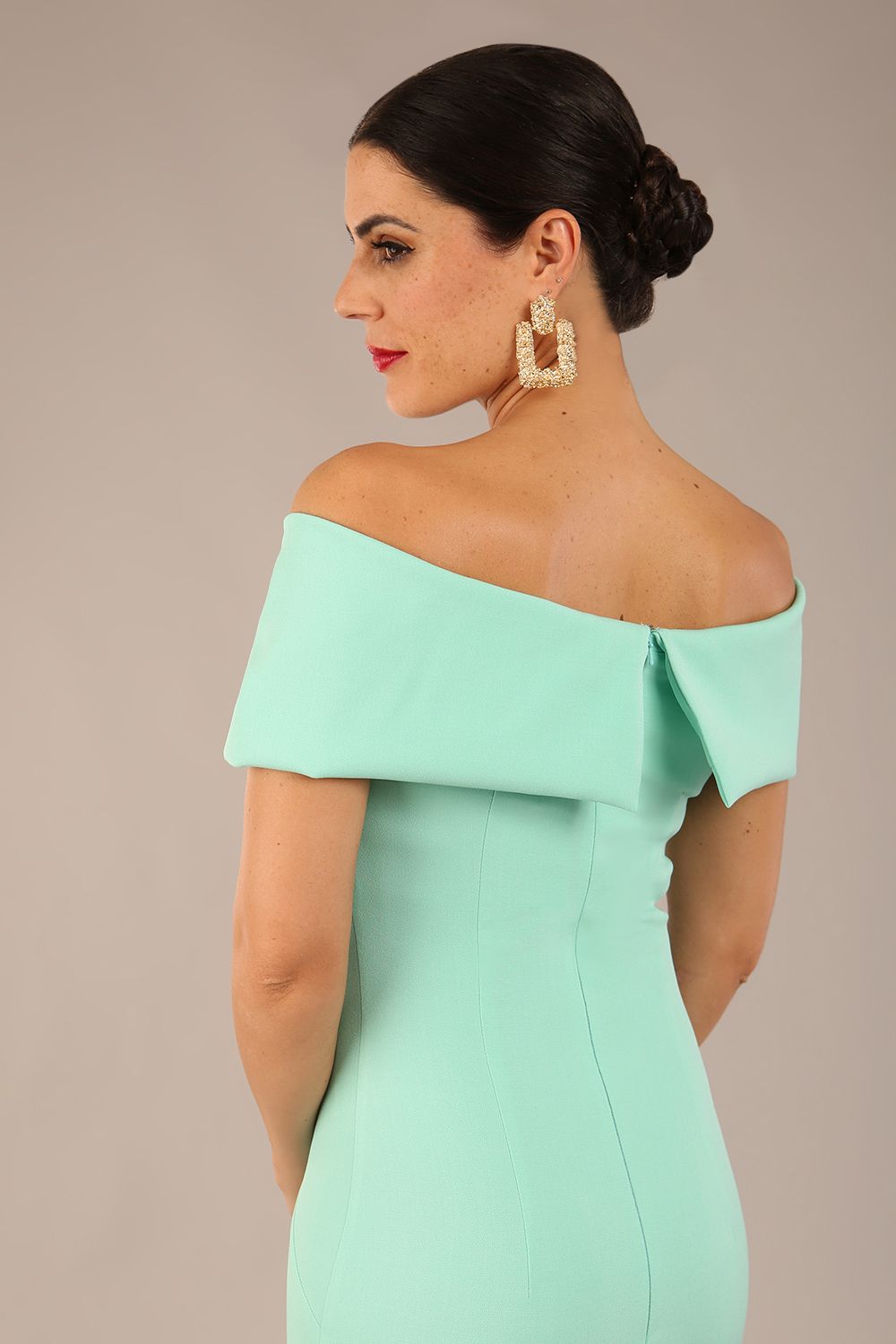 brunette model is wearing a diva catwalk Mariposa Longer Length Dress off the shoulder bardot neckline and midaxi length in mint green colour back image close up