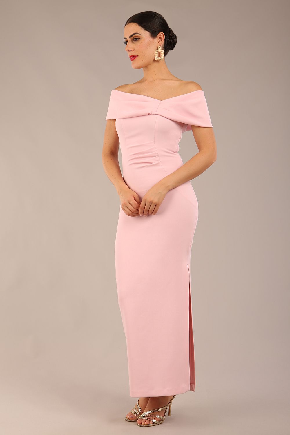 brunette model is wearing a diva catwalk Mariposa Longer Length Dress off the shoulder bardot neckline and midaxi length in crystal pink colour front image