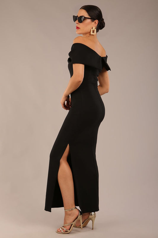 brunette model is wearing a diva catwalk Mariposa Longer Length Dress off the shoulder bardot neckline and midaxi length in black colour back image