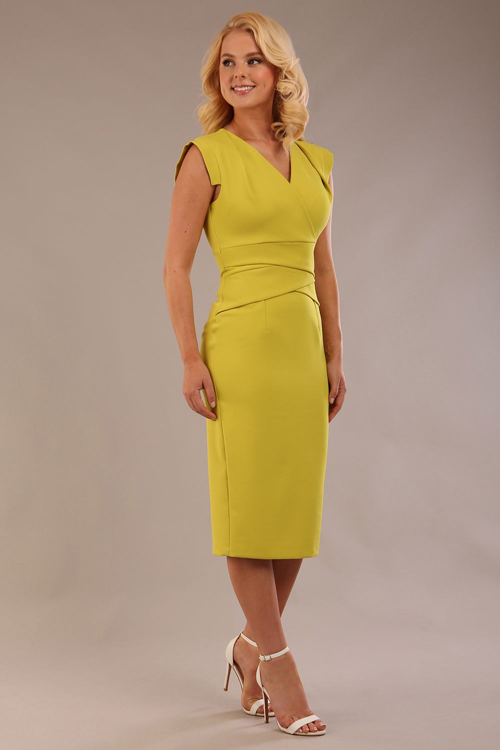 model wearing a diva catwalk Caprice Cap Sleeved Pencil Dress cap sleeve v neckline knee length with pleating details in citrus green colour front side