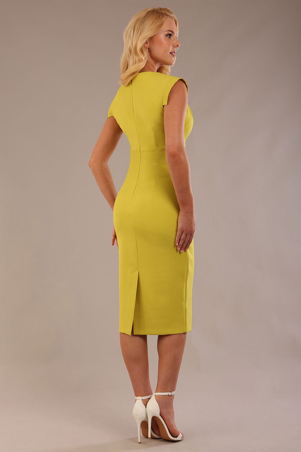 model wearing a diva catwalk Caprice Cap Sleeved Pencil Dress cap sleeve v neckline knee length with pleating details in citrus green colour back