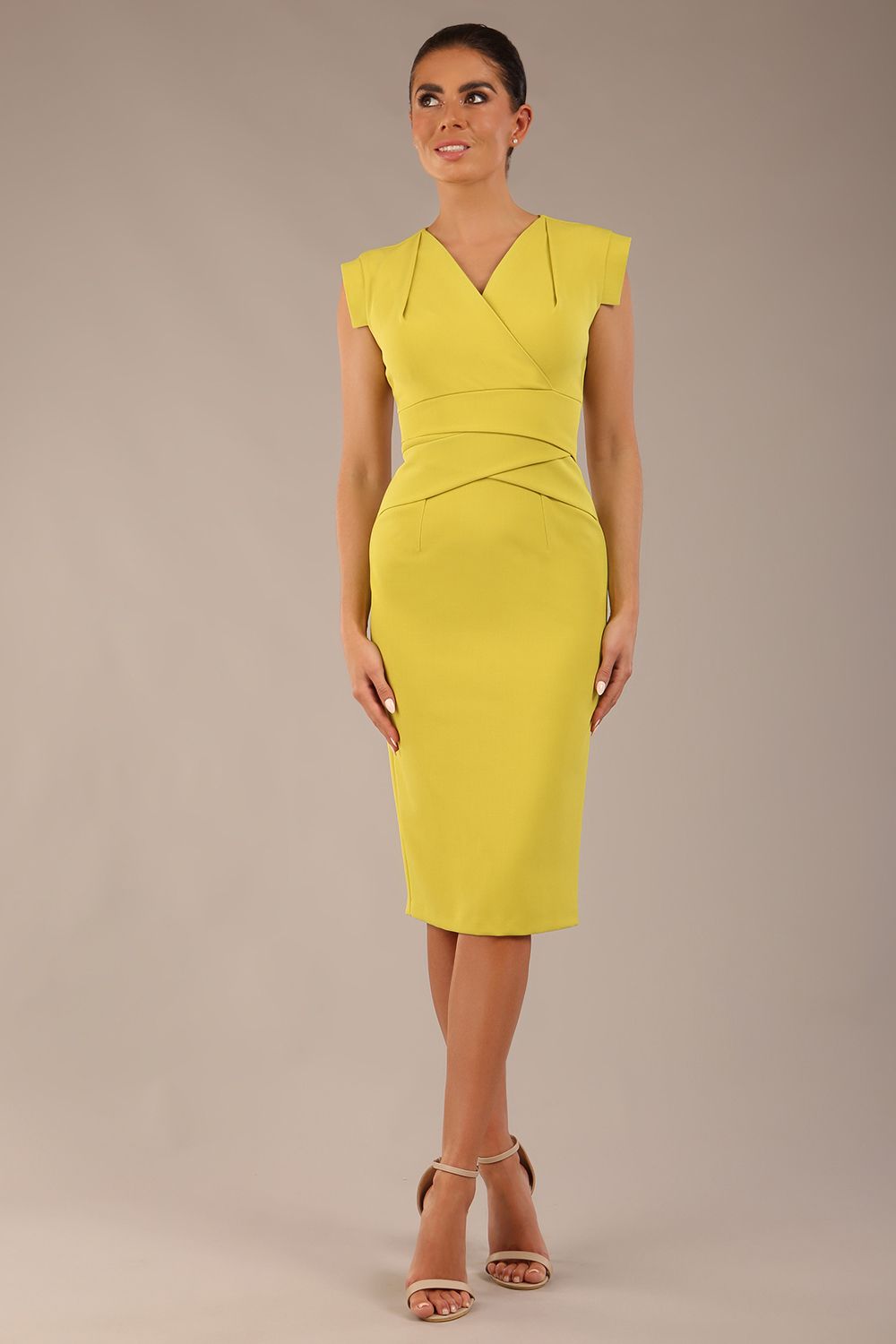 brunette model is wearing a diva catwalk Caprice Cap Sleeved Pencil Dress cap sleeve v neckline knee length with pleating details in citrus green colour front image