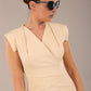 model wearing a diva catwalk Caprice Cap Sleeved Pencil Dress cap sleeve v neckline knee length with pleating details in sandshell beige colour