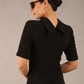 brunette model is wearing a diva catwalk Highmoor Short Sleeved Pencil Dress high neckline and shoulders pad in black colour back image