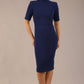 brunette model is wearing a diva catwalk Highmoor Short Sleeved Pencil Dress high neckline and shoulders pad in navy blue colour front image