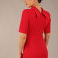 brunette model is wearing a diva catwalk Highmoor Short Sleeved Pencil Dress high neckline and shoulders pad in true red colour back image