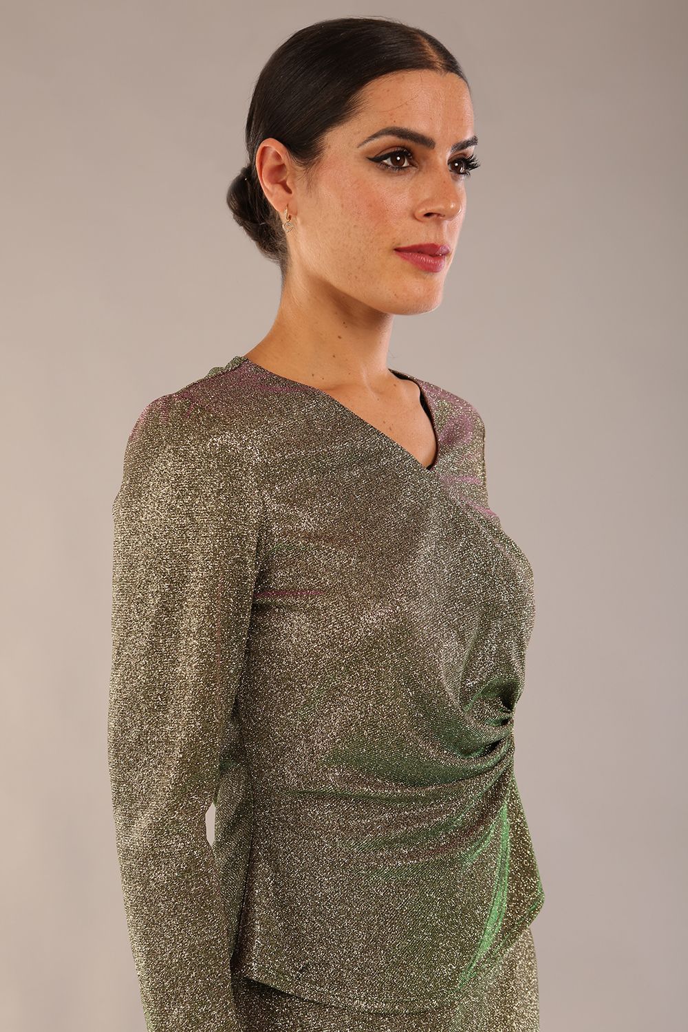 model wearing a diva catwalk Zeta Glitter Two-Piece Set with long sleeves v neckline and gathered detail on the top and side slit detail on the full length skirt in glitter stretch fabric in sherwood glitter colour - 2 pieces