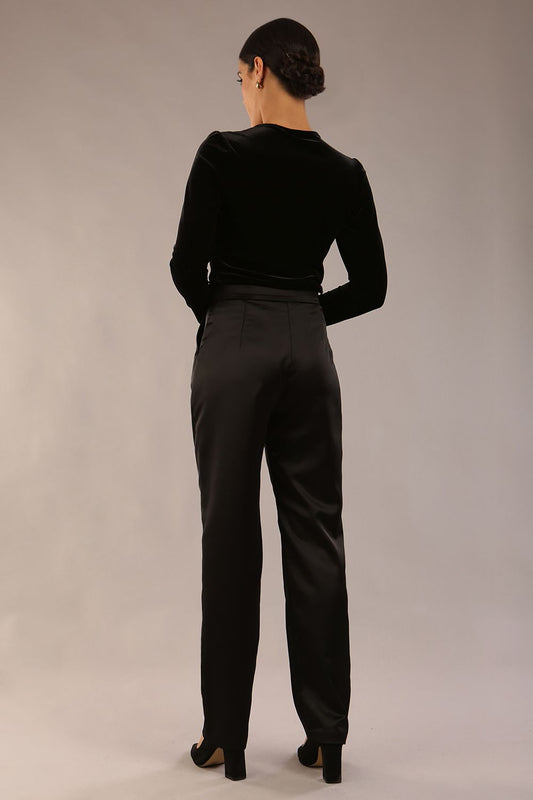 model is wearing a diva catwalk Rhea Satin Stretch Trousers with side pockets and concealed side zip and long leg in black satin back