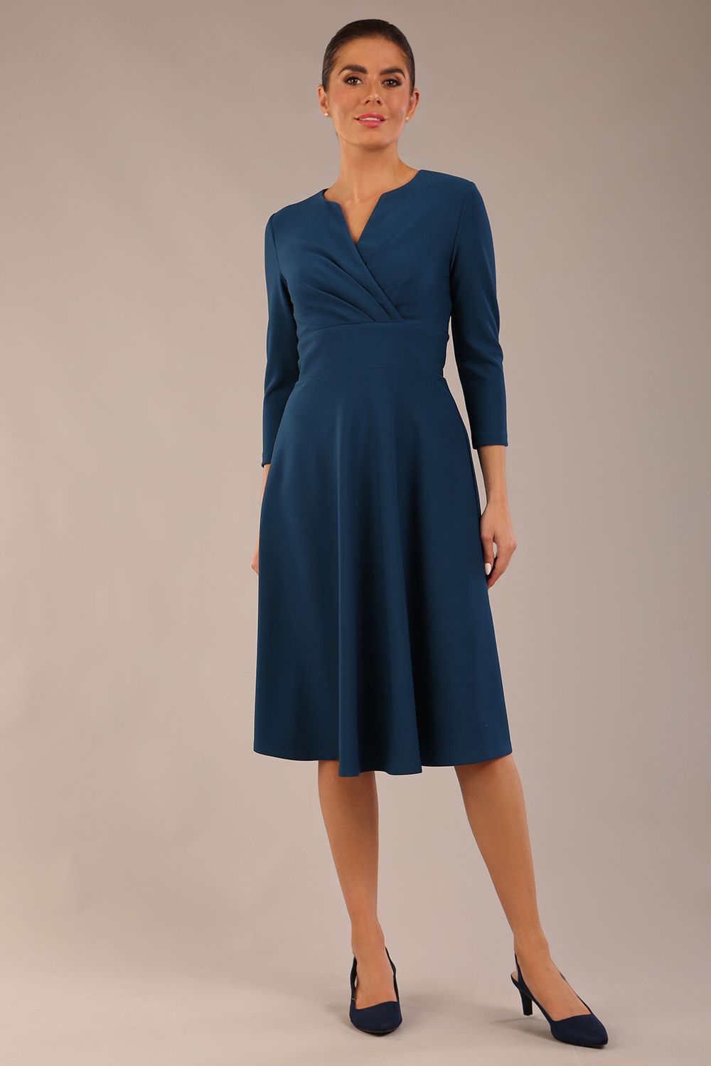 brunette model is wearing a diva catwalk Haddington sleeved A-line Dress knee length round neckline with crossover v-slit detail in teal colour front image