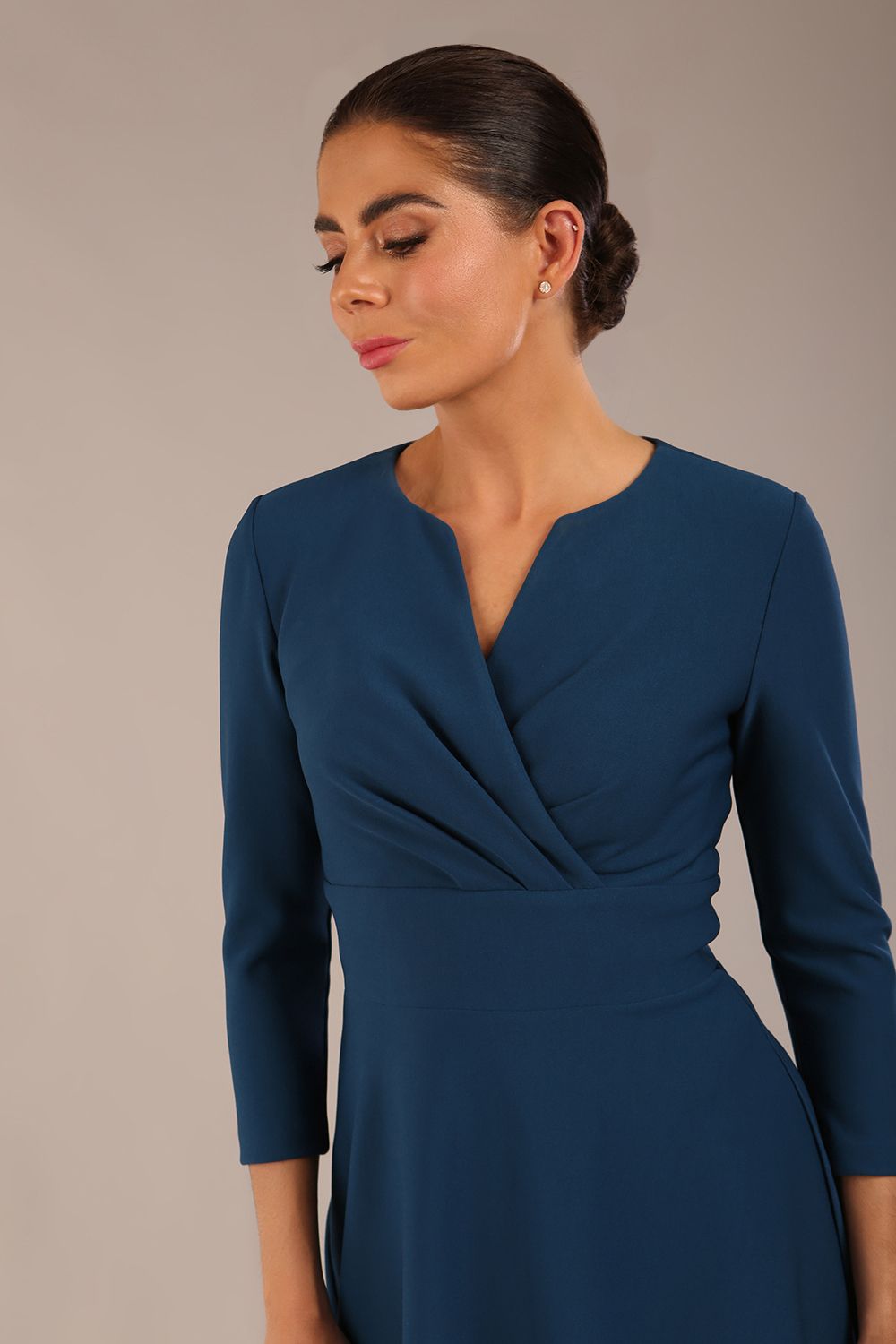 brunette model is wearing a diva catwalk Haddington sleeved A-line Dress knee length round neckline with crossover v-slit detail in teal colour front image