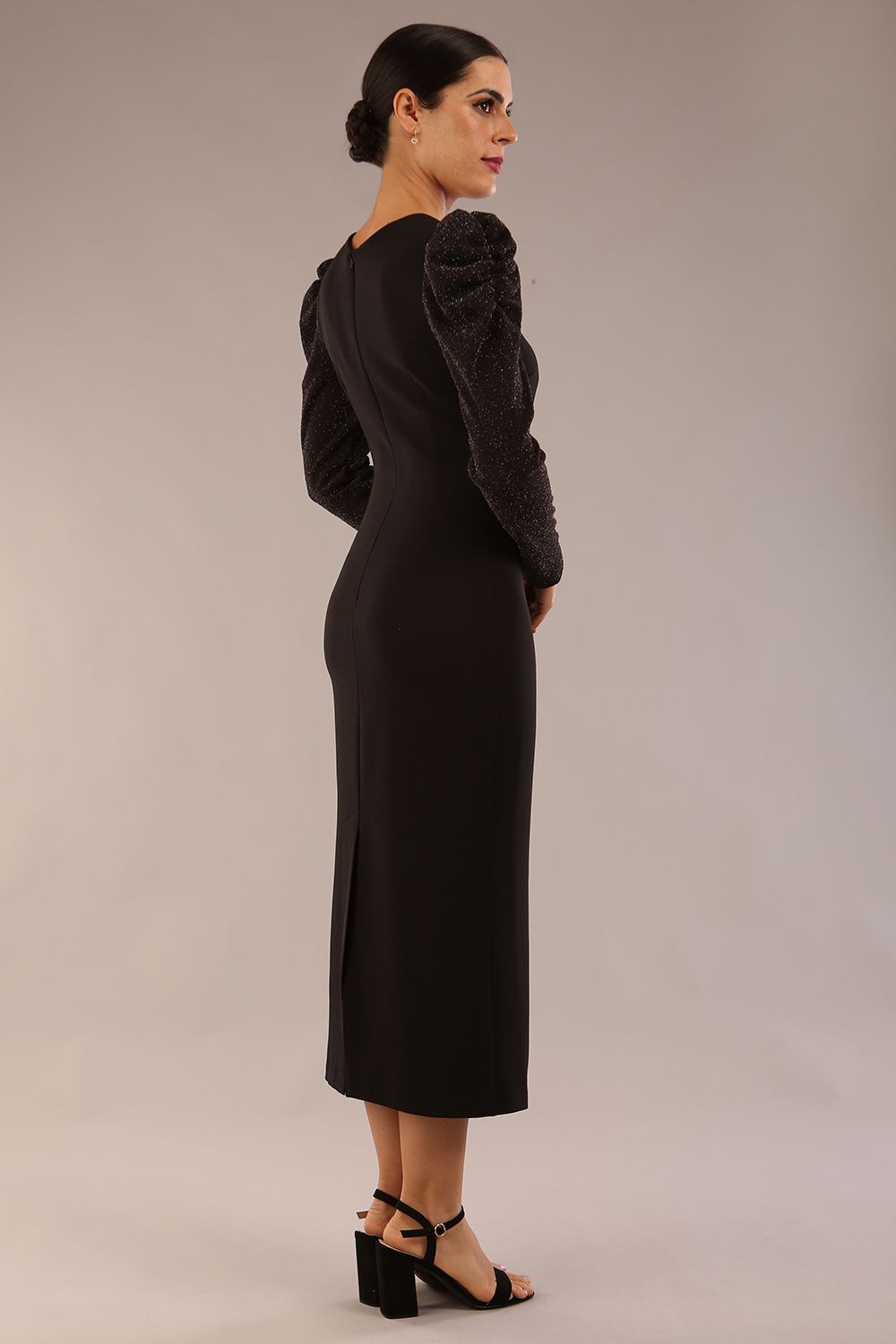 model is wearing a diva catwalk Roxanne Sparkle Asymmetric neckline and Midi Pencil Dress with long sleeves and puffed shoulders in ripple fabric and jersey sparkle  in black colour back