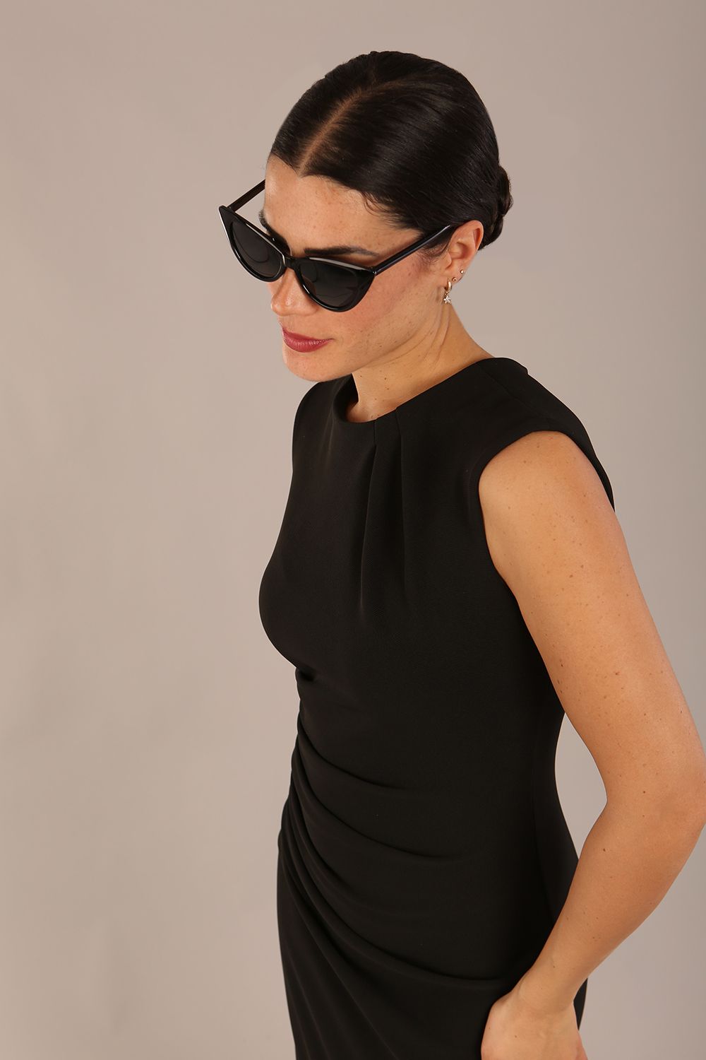 model is wearing a diva catwalk sleeveless dress with round neckline with pleating details and knee length in black colour front