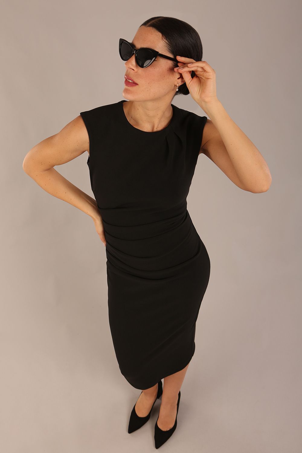 model is wearing a diva catwalk sleeveless dress with round neckline with pleating details and knee length in black colour front