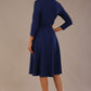 brunette model is wearing a diva catwalk Haddington sleeved A-line Dress knee length round neckline with crossover v-slit detail in navy blue colour back image