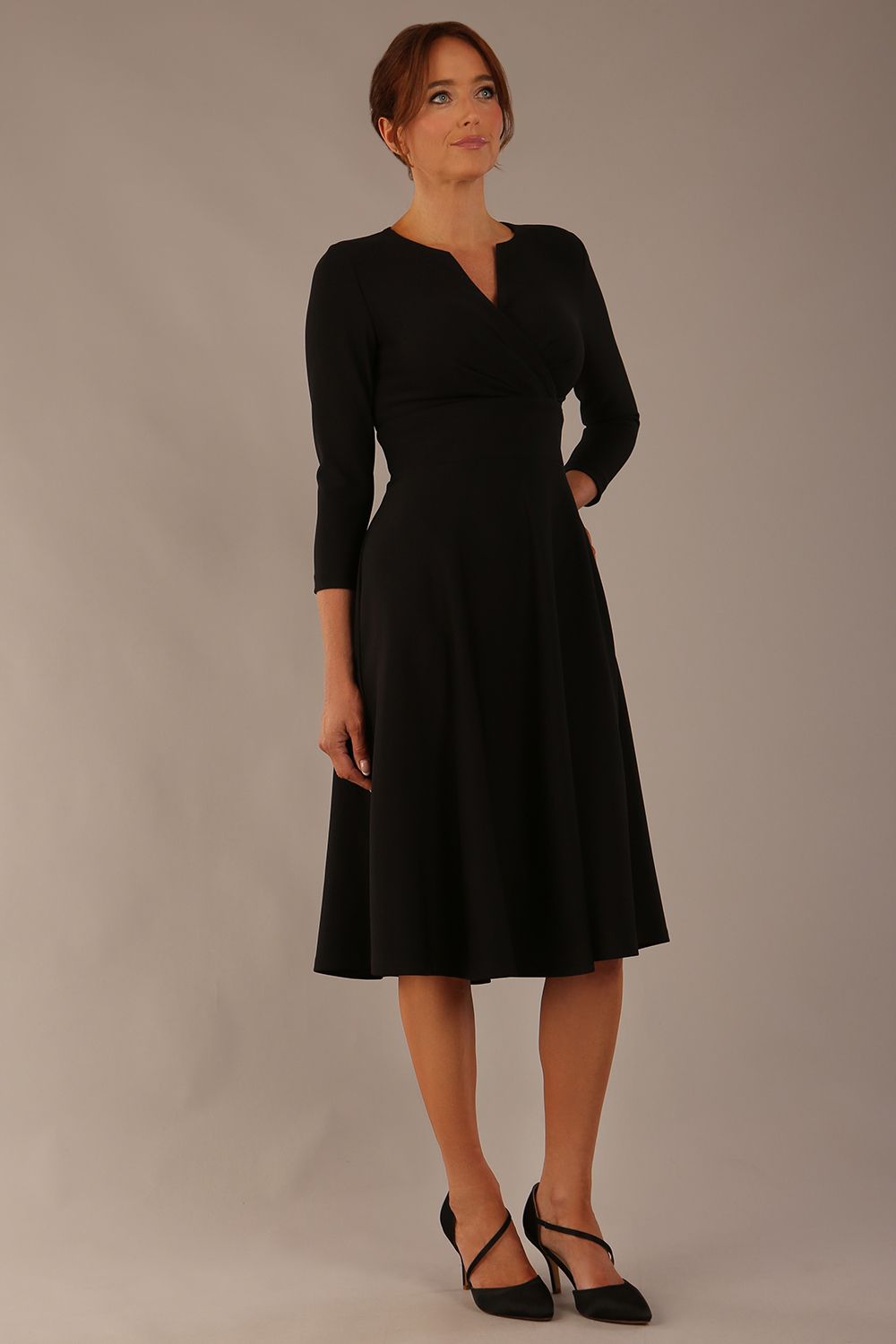 brunette model is wearing a diva catwalk Haddington sleeved A-line Dress knee length round neckline with crossover v-slit detail in black colour front image 