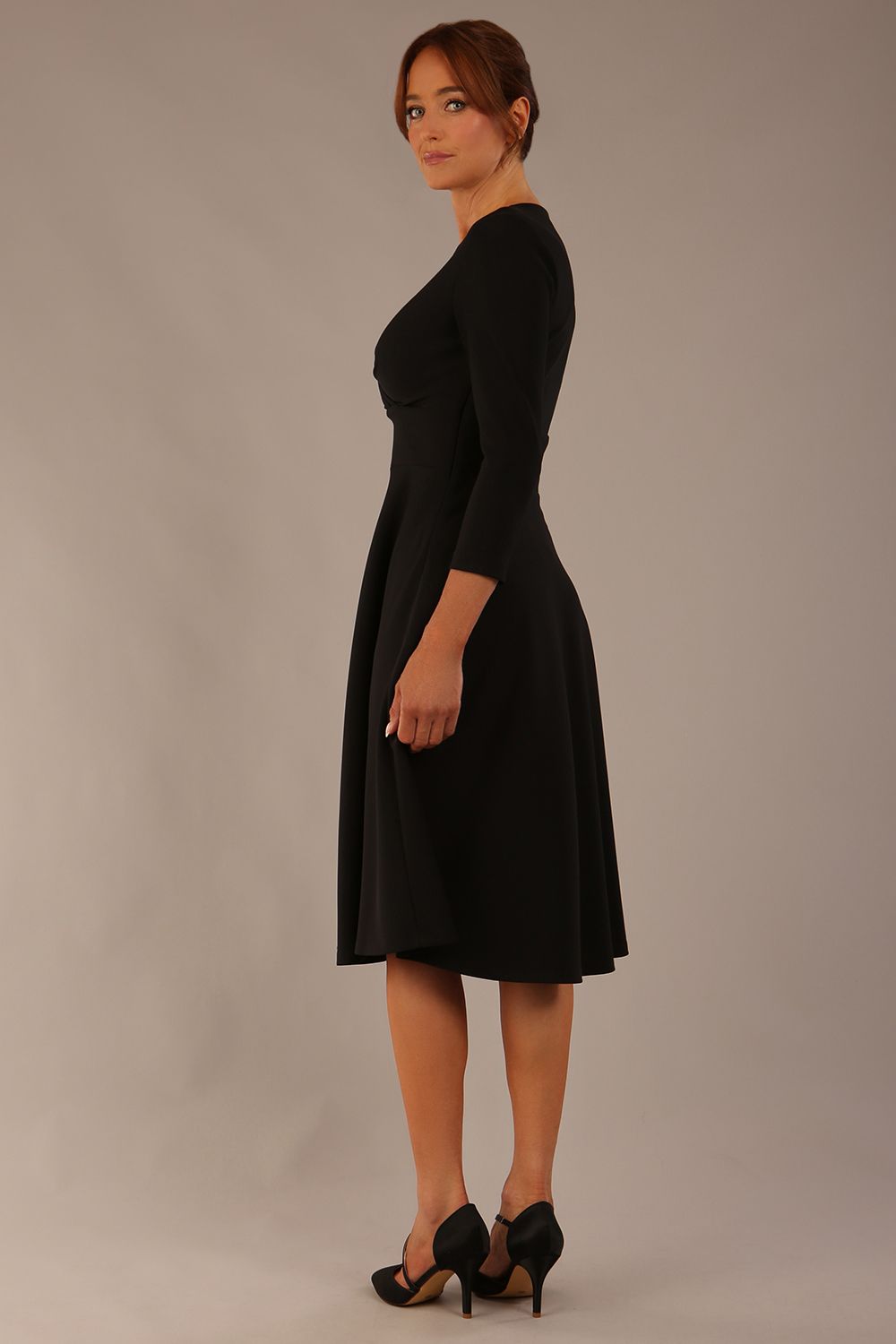 brunette model is wearing a diva catwalk Haddington sleeved A-line Dress knee length round neckline with crossover v-slit detail in black colour back image 