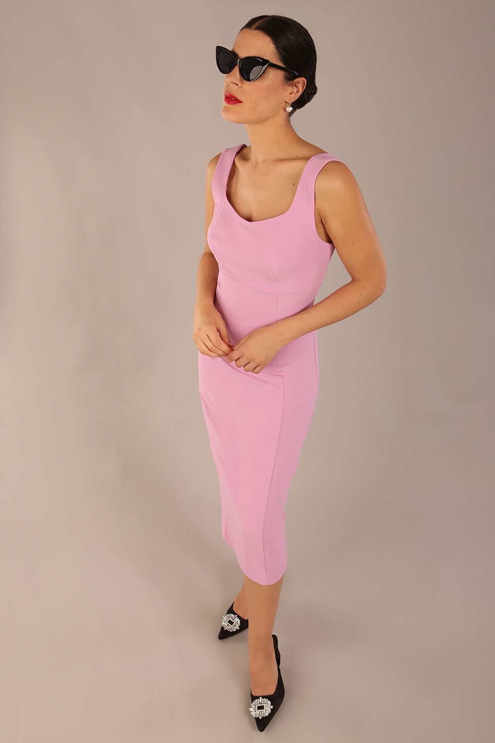 brunette model is wearing a diva catwalk Perthshire Sleeveless Bodycon Pencil Dress square neckline in dawn pink colour front image 