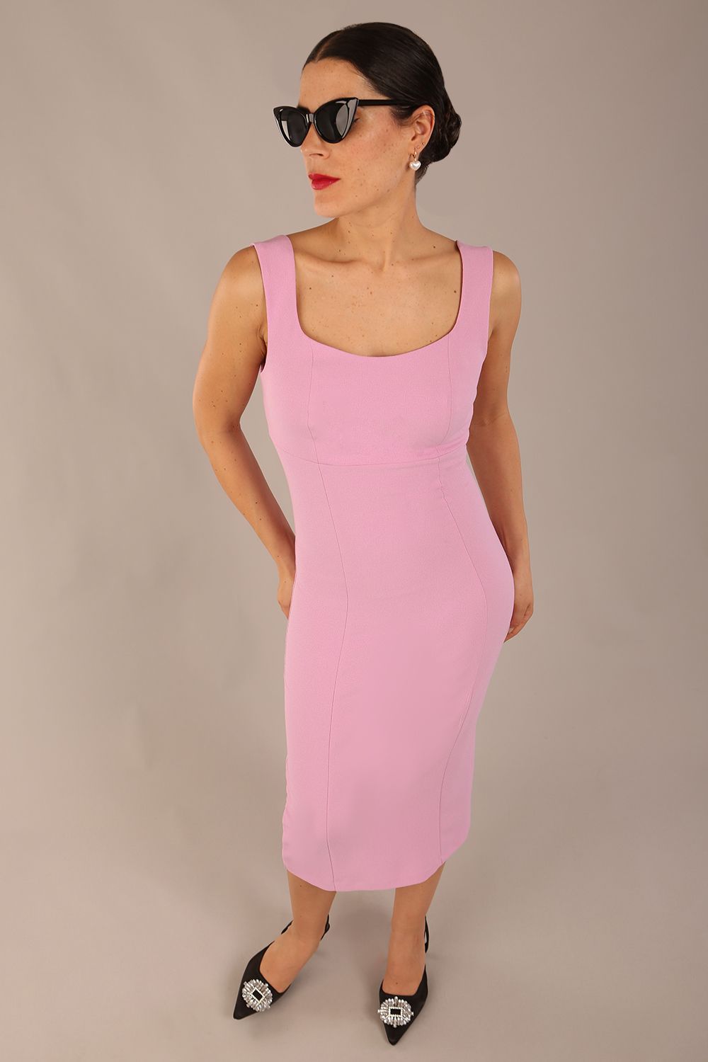 brunette model is wearing a diva catwalk Perthshire Sleeveless Bodycon Pencil Dress square neckline in dawn pink colour front image 