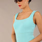 brunette model is wearing a diva catwalk Perthshire Sleeveless Bodycon Pencil Dress square neckline in turquoise colour front image 
