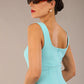 brunette model is wearing a diva catwalk Perthshire Sleeveless Bodycon Pencil Dress square neckline in turquoise colour front image 