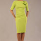 brunette model is wearing a diva catwalk Reverie Short Sleeve Stretch Pencil Dress with Bow Detail in lime green colour front image