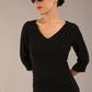 brunette model is wearing a  diva catwalk Tara V-neckline Sleeved Pencil Dress knee length in black colour front image with sunglasses