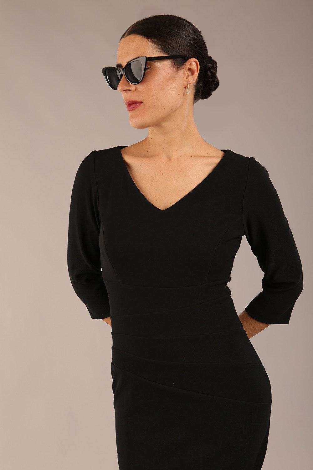 brunette model is wearing a  diva catwalk Tara V-neckline Sleeved Pencil Dress knee length in black colour front image with sunglasses