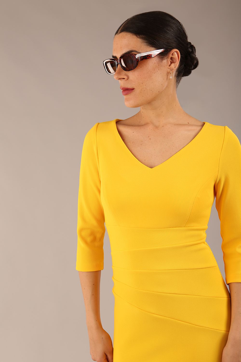 brunette model is wearing a  diva catwalk Tara V-neckline Sleeved Pencil Dress knee length in sunshine yellow colour front image with sunglasses