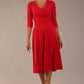brunette model is wearing a diva catwalk Fabienne sleeved A-line Dress with pockets v neckline knee length wide waistband fold over v neckline in electric red colour front image