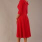 brunette model is wearing a diva catwalk Fabienne sleeved A-line Dress with pockets v neckline knee length wide waistband fold over v neckline in electric red colour back image