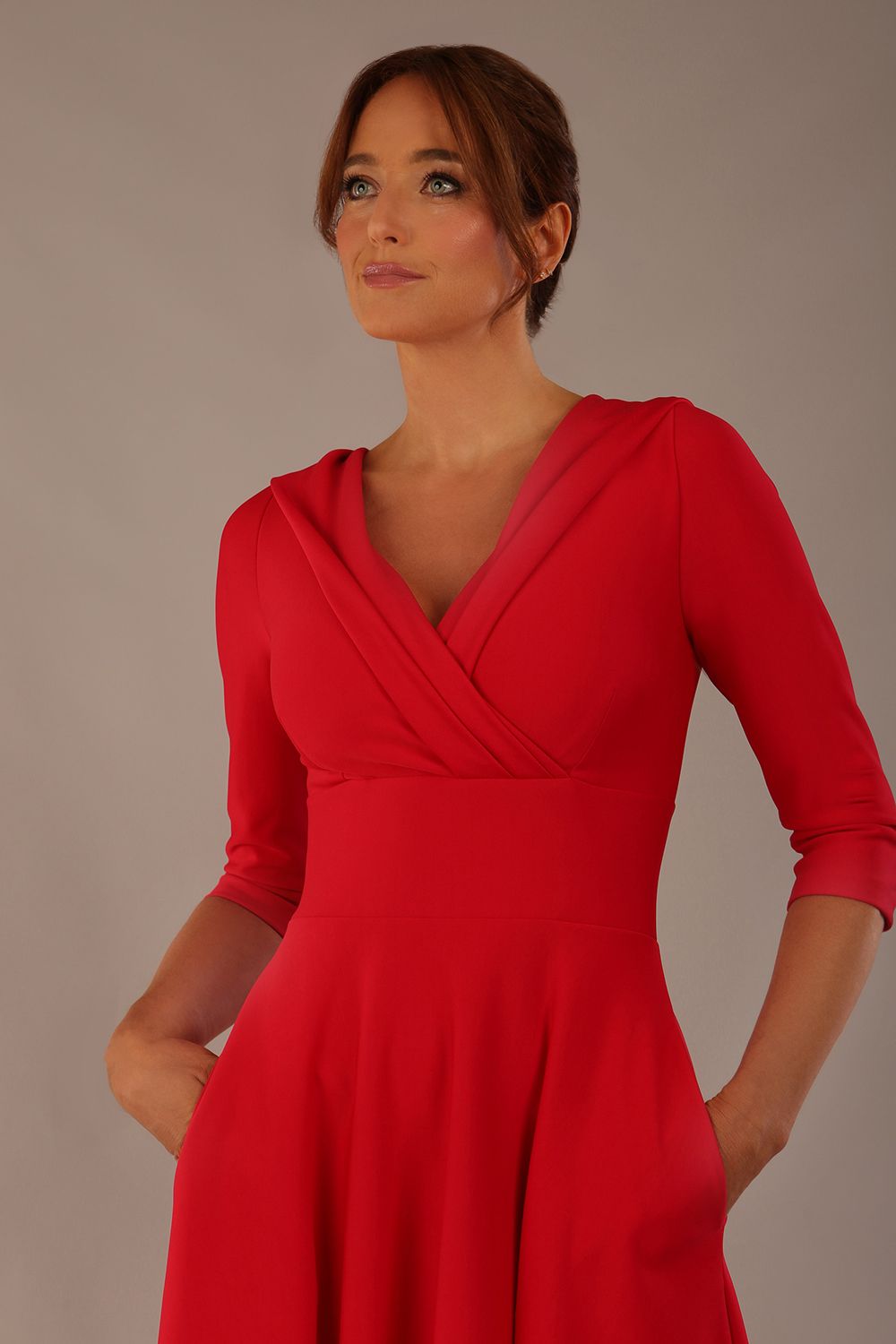 brunette model is wearing a diva catwalk Fabienne sleeved A-line Dress with pockets v neckline knee length wide waistband fold over v neckline in electric red colour front image close up