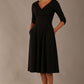 brunette model is wearing a diva catwalk Fabienne sleeved A-line Dress with pockets v neckline knee length wide waistband fold over v neckline in black colour front image