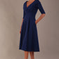 brunette model is wearing a diva catwalk Fabienne sleeved A-line Dress with pockets v neckline knee length wide waistband fold over v neckline in navy blue colour front image