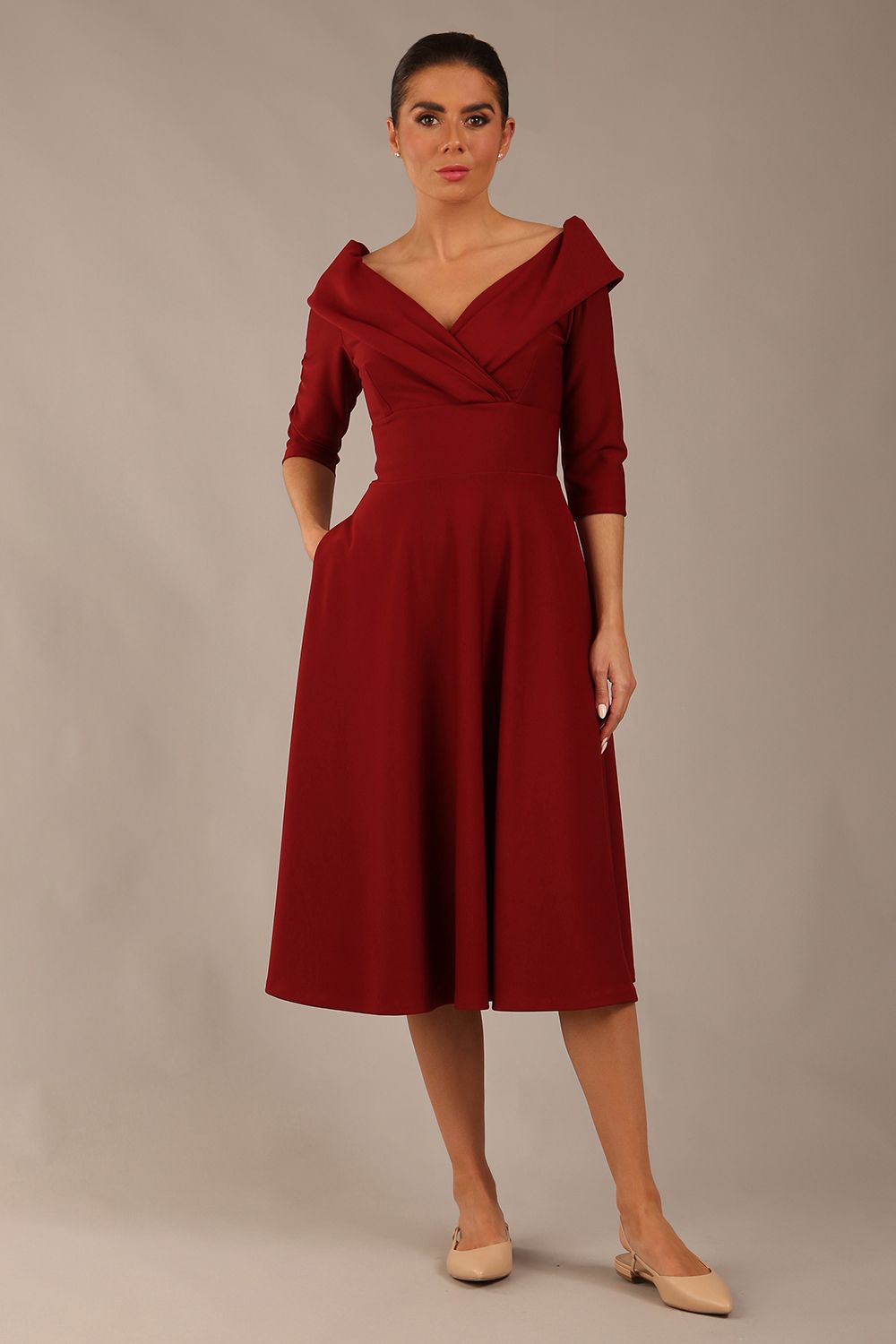 brunette model is wearing a diva catwalk Fabienne sleeved A-line Dress with pockets v neckline knee length wide waistband fold over v neckline in burgundy colour front image