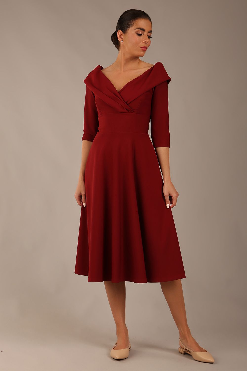 brunette model is wearing a diva catwalk Fabienne sleeved A-line Dress with pockets v neckline knee length wide waistband fold over v neckline in burgundy colour front image