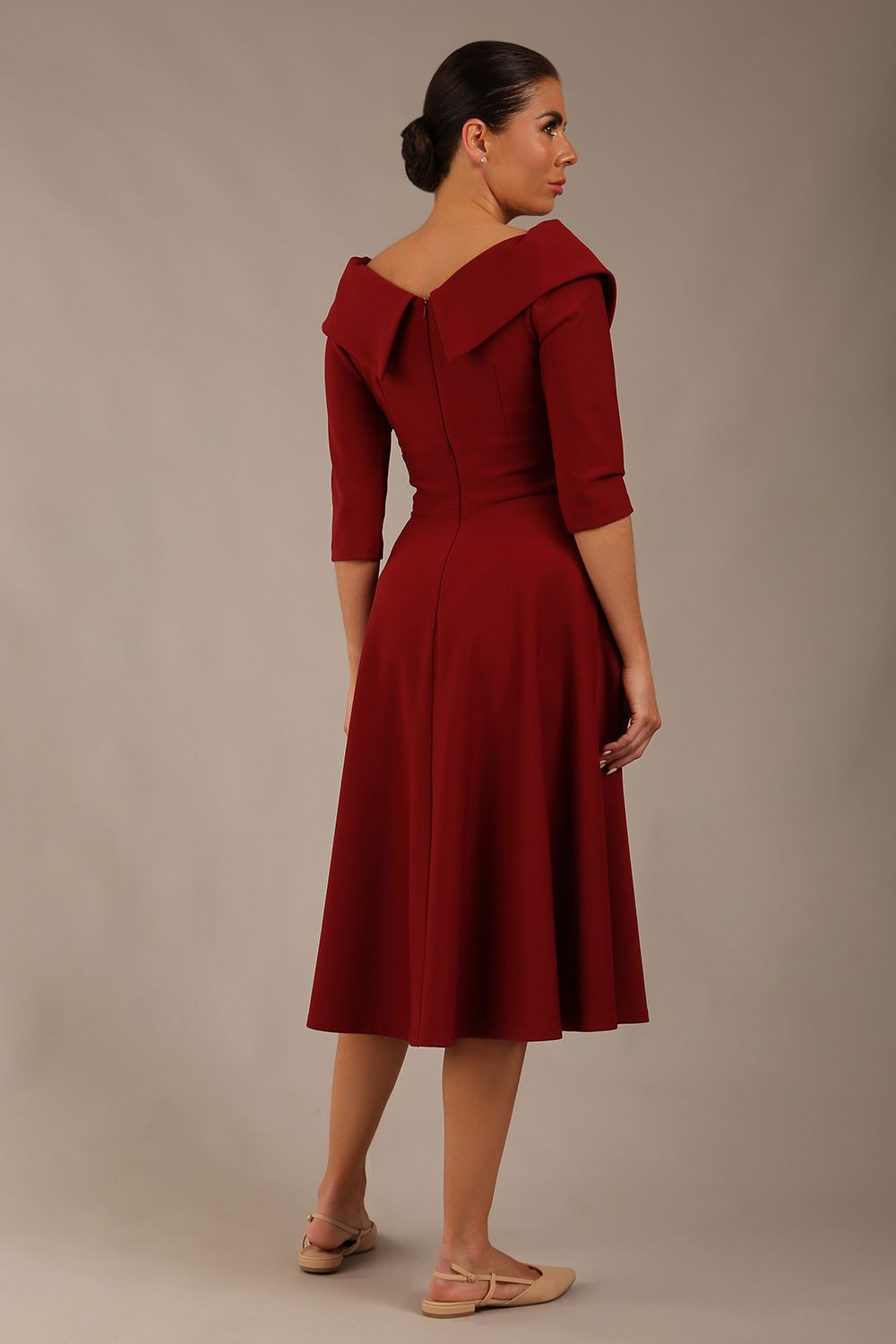 brunette model is wearing a diva catwalk Fabienne sleeved A-line Dress with pockets v neckline knee length wide waistband fold over v neckline in burgundy colour back image