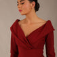 brunette model is wearing a diva catwalk Fabienne sleeved A-line Dress with pockets v neckline knee length wide waistband fold over v neckline in burgundy colour front image close up